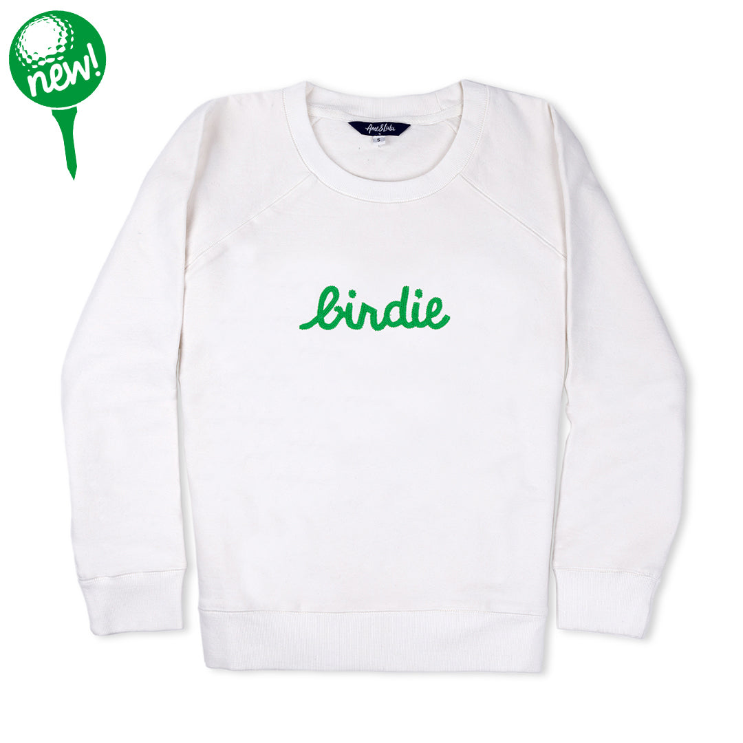 White sweatshirt lays flat on white background with green text reading birdie embroidered on the front