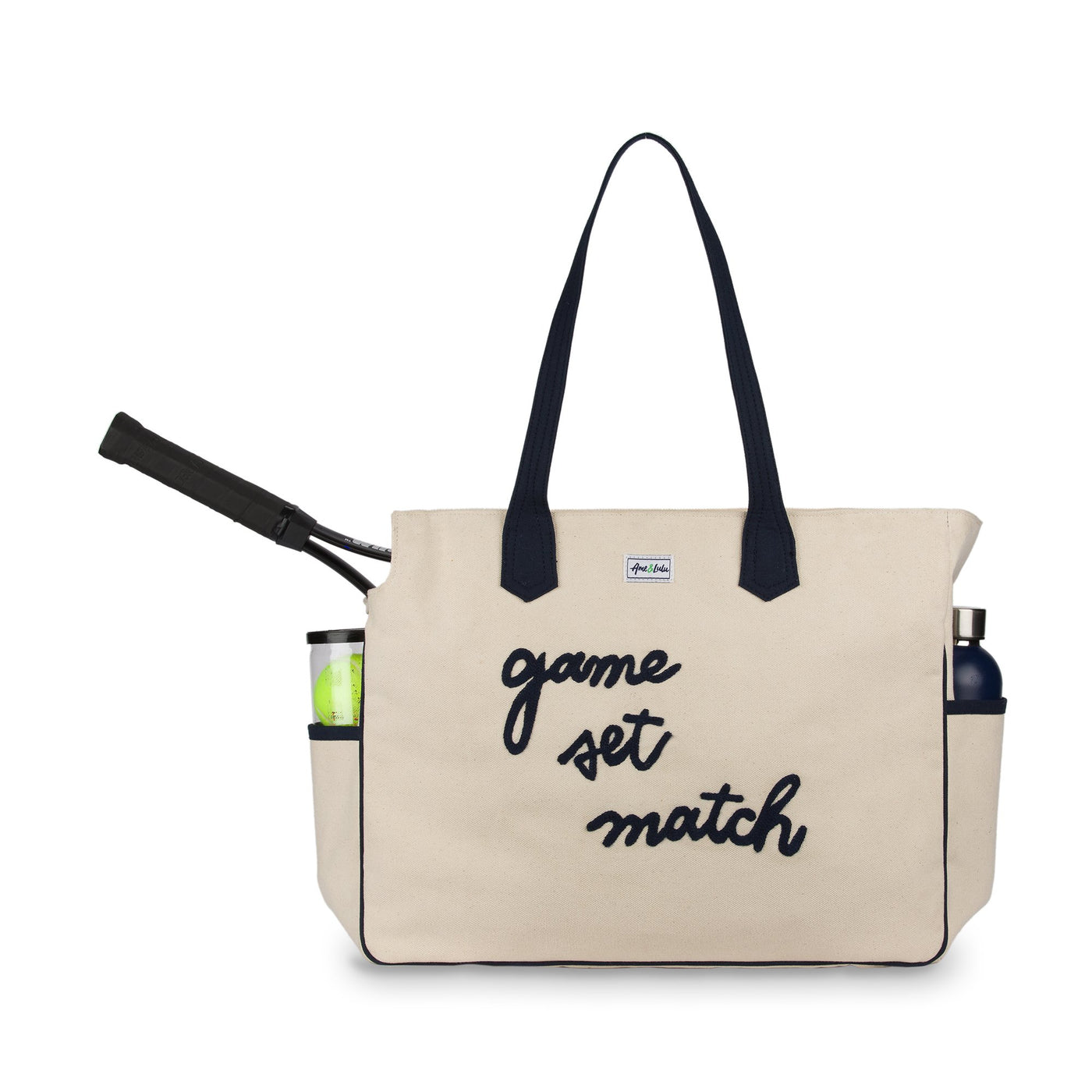 Front view of love all court bag. Large canvas tennis tote with the phrase "game set match' embroidered in a cursive font across the front of the bag.