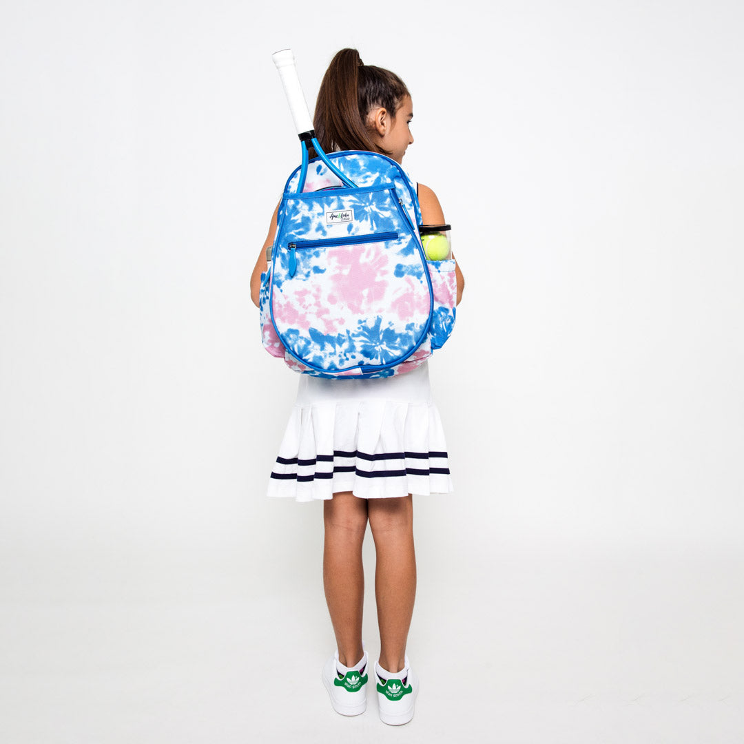 Little girl wearing kid's tennis backpack with pink and blue tye dye pattern.