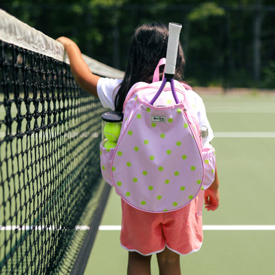 Kids tennis backpack with front pocket to hold tennis racquet. Bag is printed with a pink and white striped pattern and repeating tennis balls on the stripes.