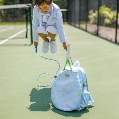 Kids tennis backpack with front pocket to hold tennis racquet. Bag is printed with a blue and white striped pattern and repeating tennis balls on the stripes.