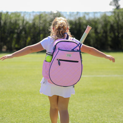 Front view of blush pink quilted kids tennis backpack with navy trim and zippers.