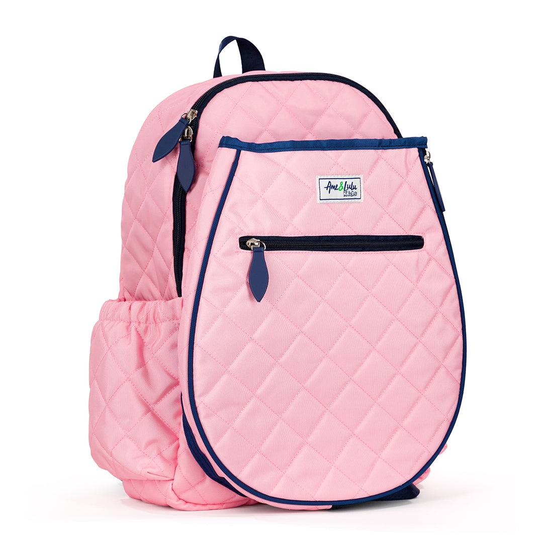 Side view of blush pink quilted kids tennis backpack with navy trim and zippers.