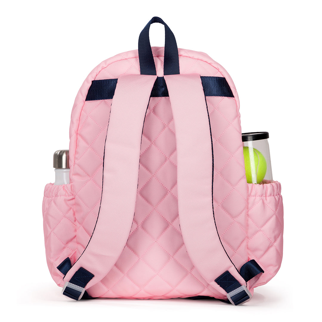 Back view of blush pink quilted kids tennis backpack with navy trim and zippers.
