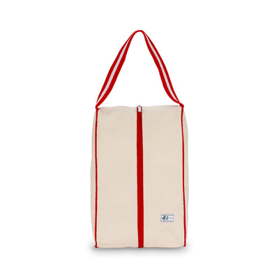 rectangular tan canvas shoe bag with red handles.