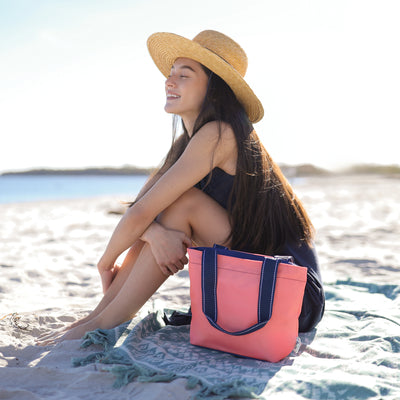 view of coral mini surfside tote with navy straps
