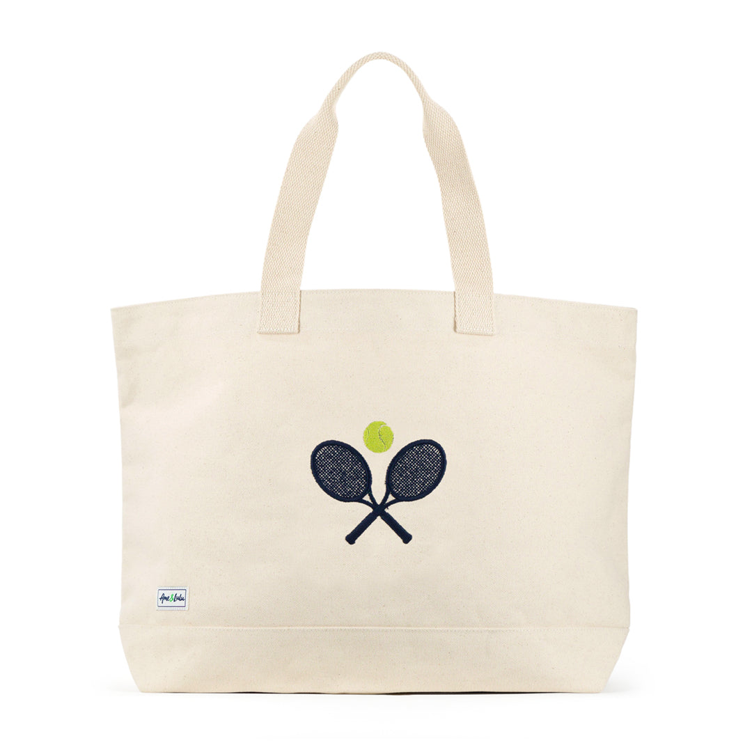 Front view of large canvas tote with crossed racquets and tennis ball embroidered on front.