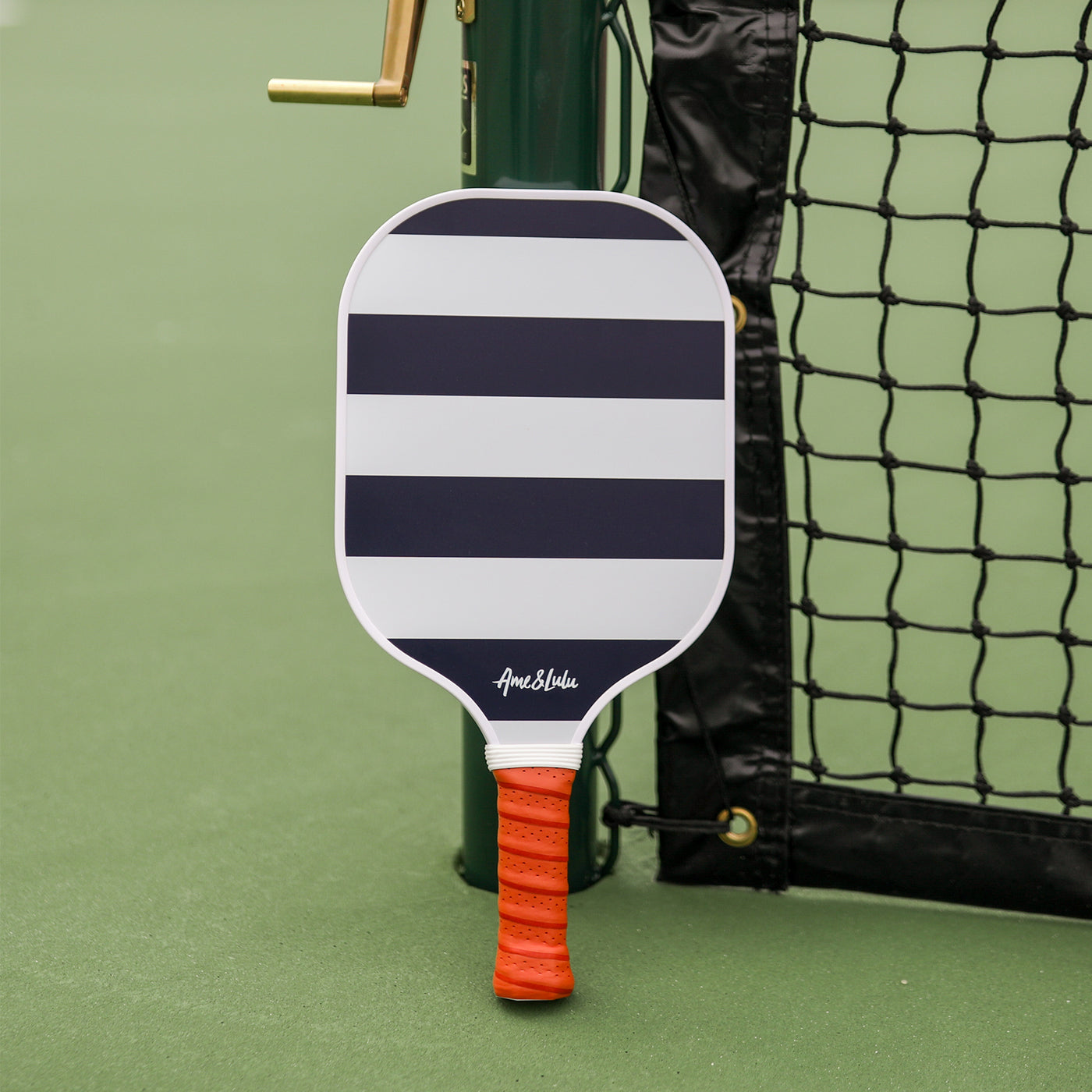 Navy and white striped pickleball paddle with tan faux leather handle.