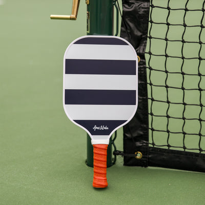 Navy and white striped pickleball paddle with tan faux leather handle.