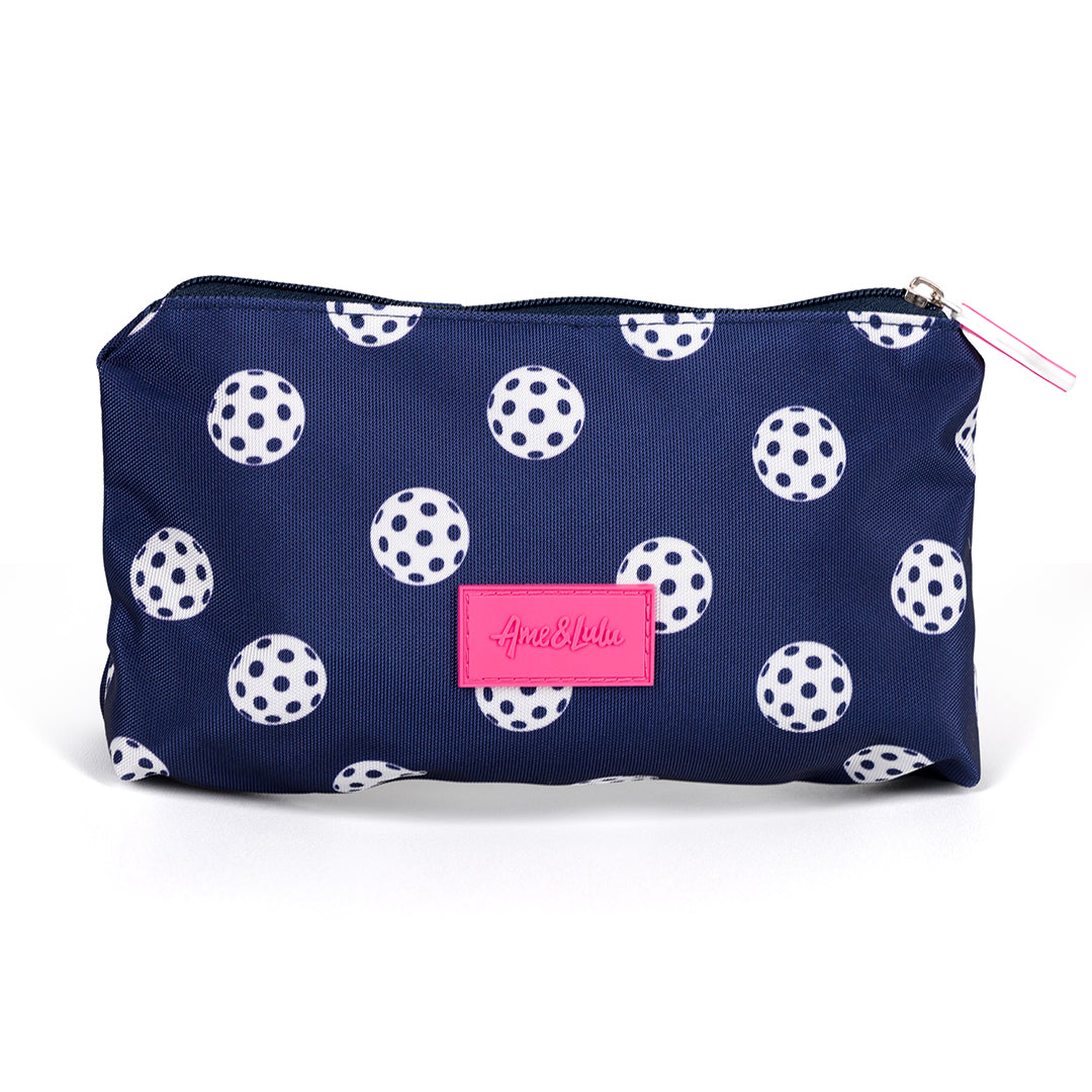 Back view of navy nylon small makeup pouch. Pouch has white pickleball printed on it and a hot pink pickleball paddle zipper.