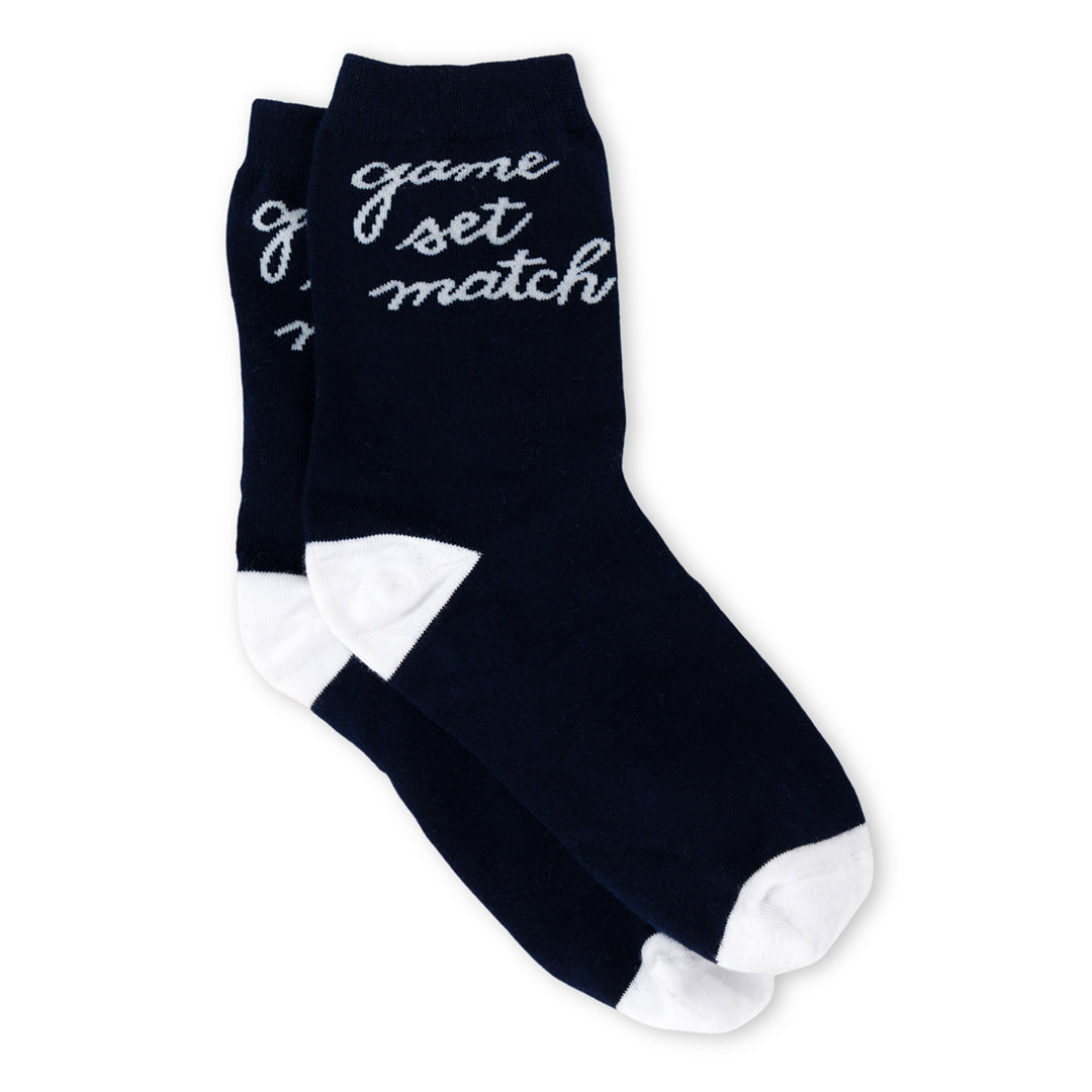 a pair of navy socks with white heel and toes. White text that reads game set match in cursive font around ankle