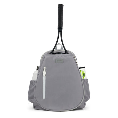 Front view of grey tennis backpack with white zipper on the front. There is a tennis racquet in the front pocket and a water bottle and tennis balls in the side pockets.