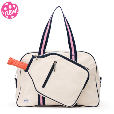 Front view of natural canvas pickleball tote with navy trim and navy and pink straps and handles.