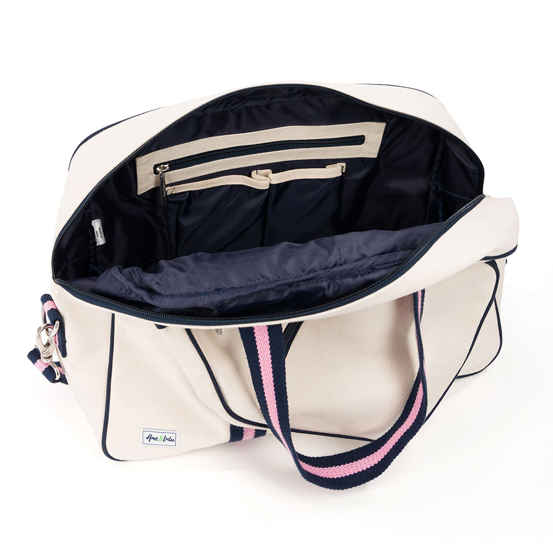Inside view of natural canvas pickleball tote with navy trim and navy and pink straps and handles.