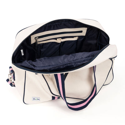 Inside view of natural canvas pickleball tote with navy trim and navy and pink straps and handles.