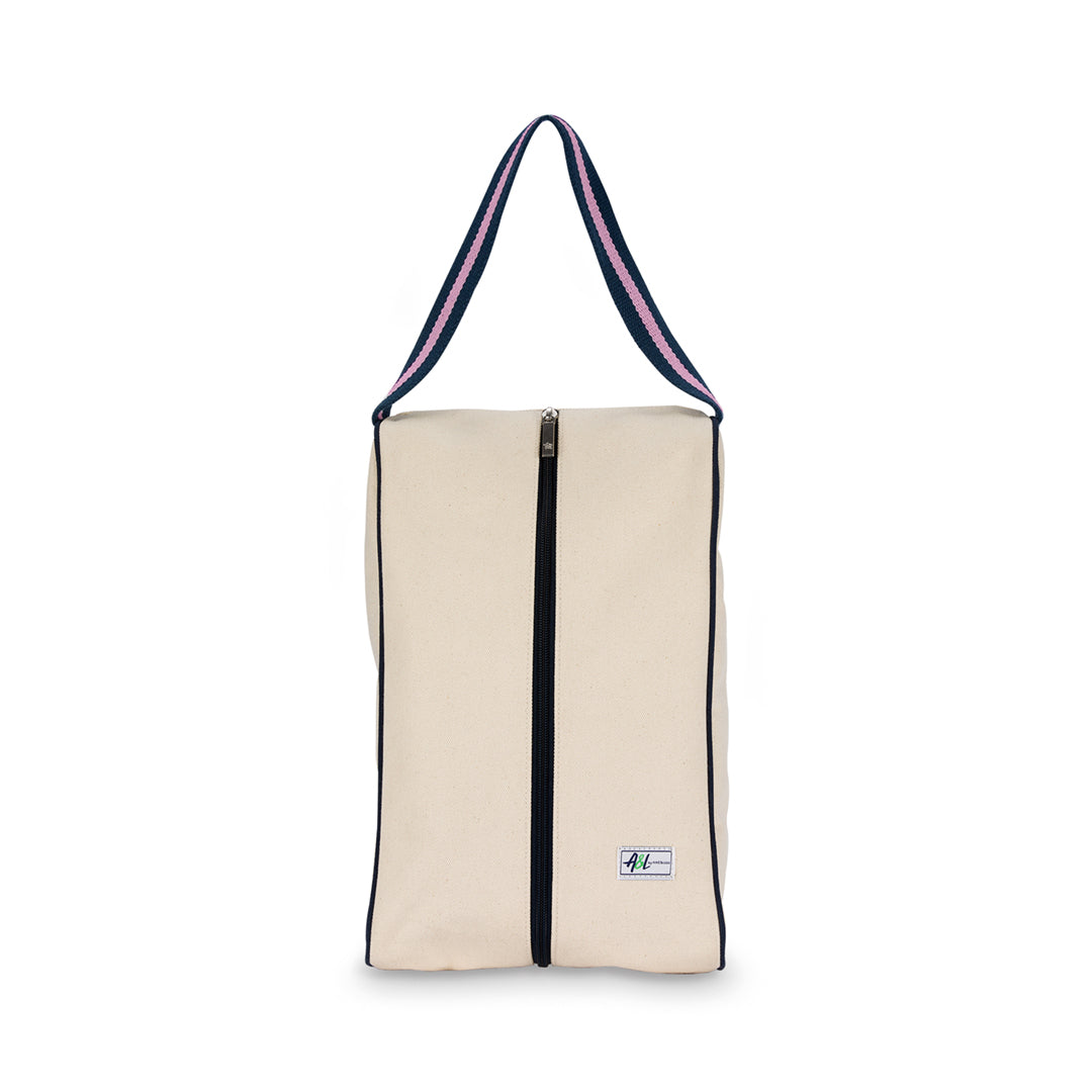 rectangular tan canvas shoe bag with navy and pink handles.