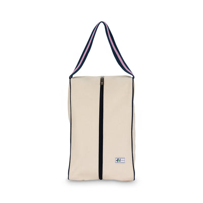 rectangular tan canvas shoe bag with navy and pink handles.