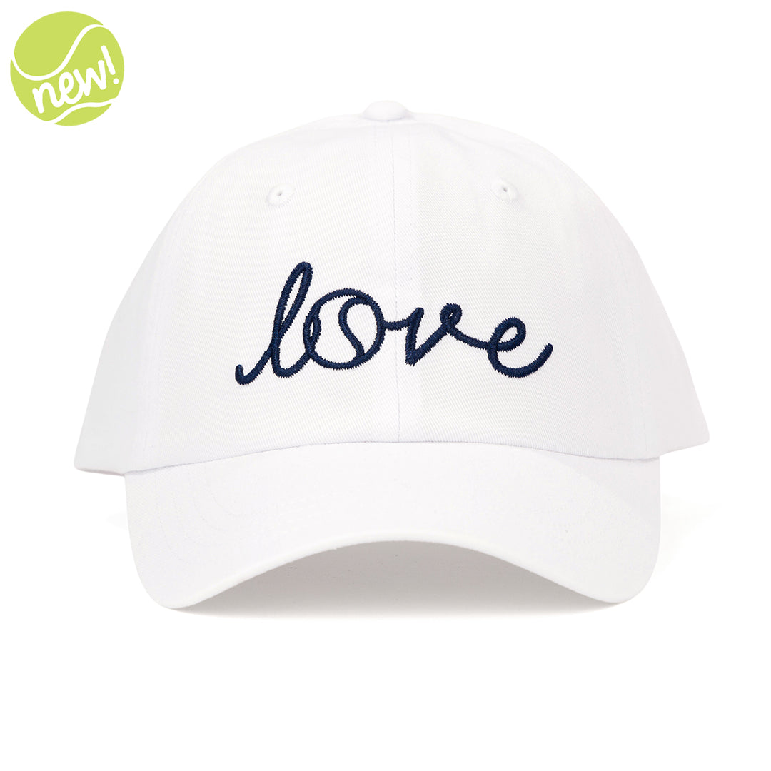 White baseball hat on white background with word "love" embroidered on the front in navy cursive