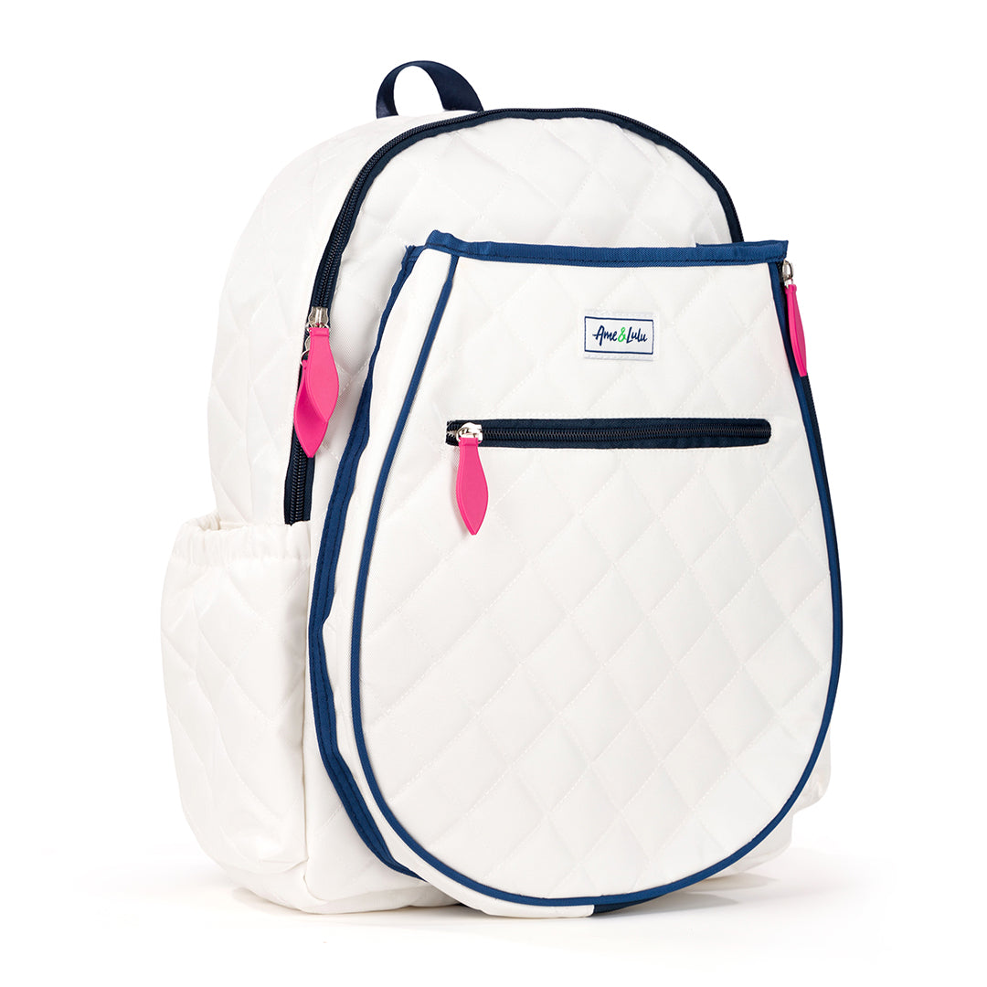 Side view of quilted white kids tennis backpack with navy trim and hot pink zippers.