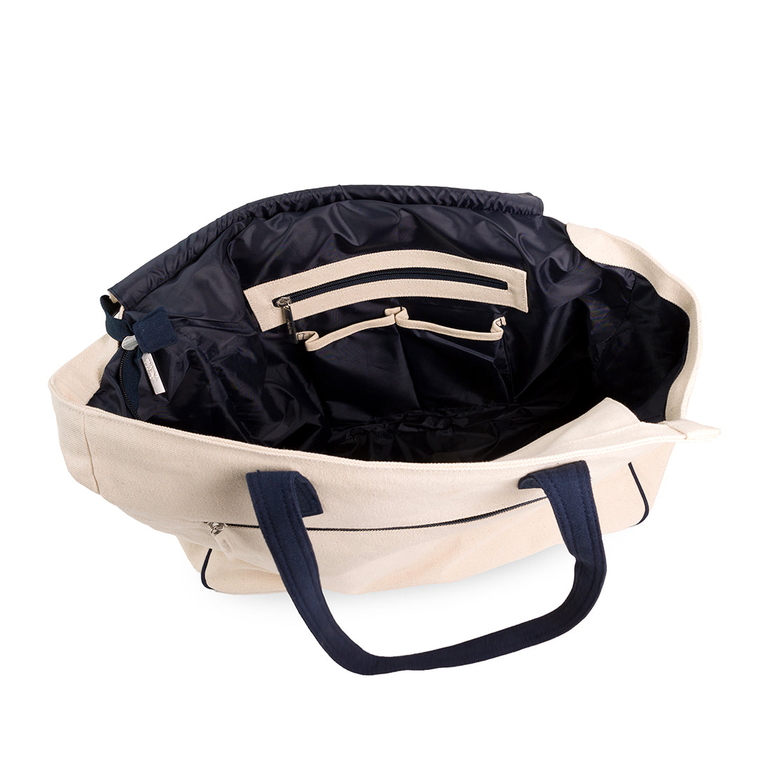 inside of Natural canvas tote with navy straps and front panel embroidered with navy crossed racquets and lime tennis ball.