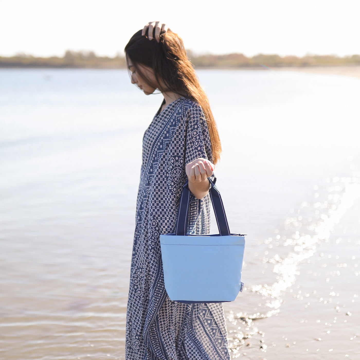 view of light blue mini surfside tote with navy straps