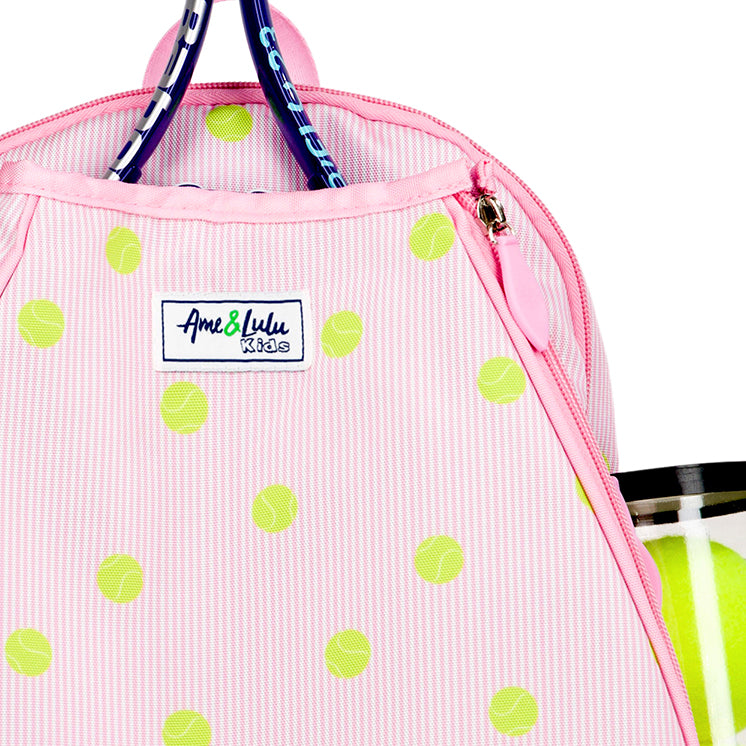 Kids tennis backpack with front pocket to hold tennis racquet. Bag is printed with a pink and white striped pattern and repeating tennis balls on the stripes.