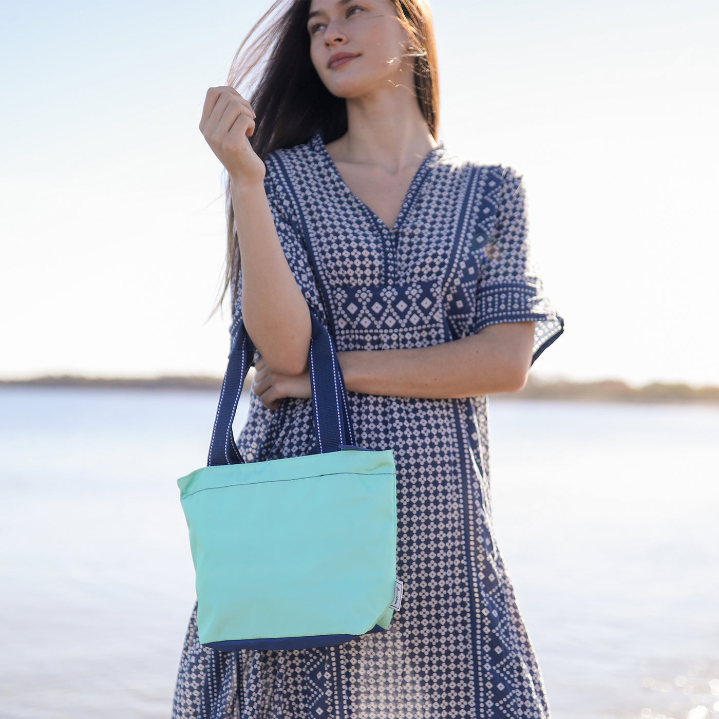 view of mint mini surfside tote with navy straps