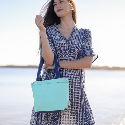 view of mint mini surfside tote with navy straps
