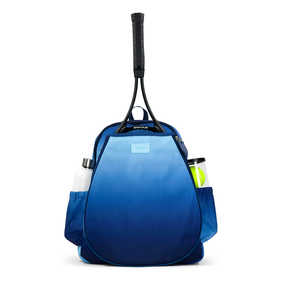 Front view of navy and blue ombre game on tennis backpack. Backpack has water bottle and tennis balls in side pockets.