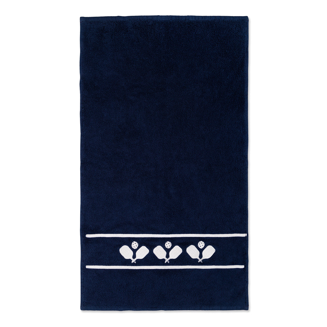 Navy cotton terry towel with three sets of white crossed paddles embroidered on the bottom of the towel