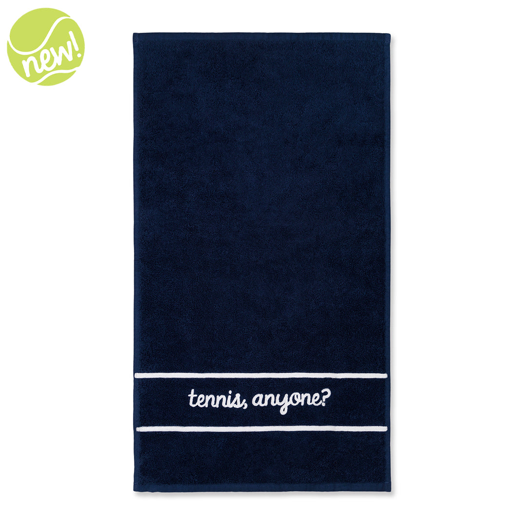 Navy cotton terry towel with the words "tennis anyone" embroidered in a cursive font in white on the bottom of the towel.