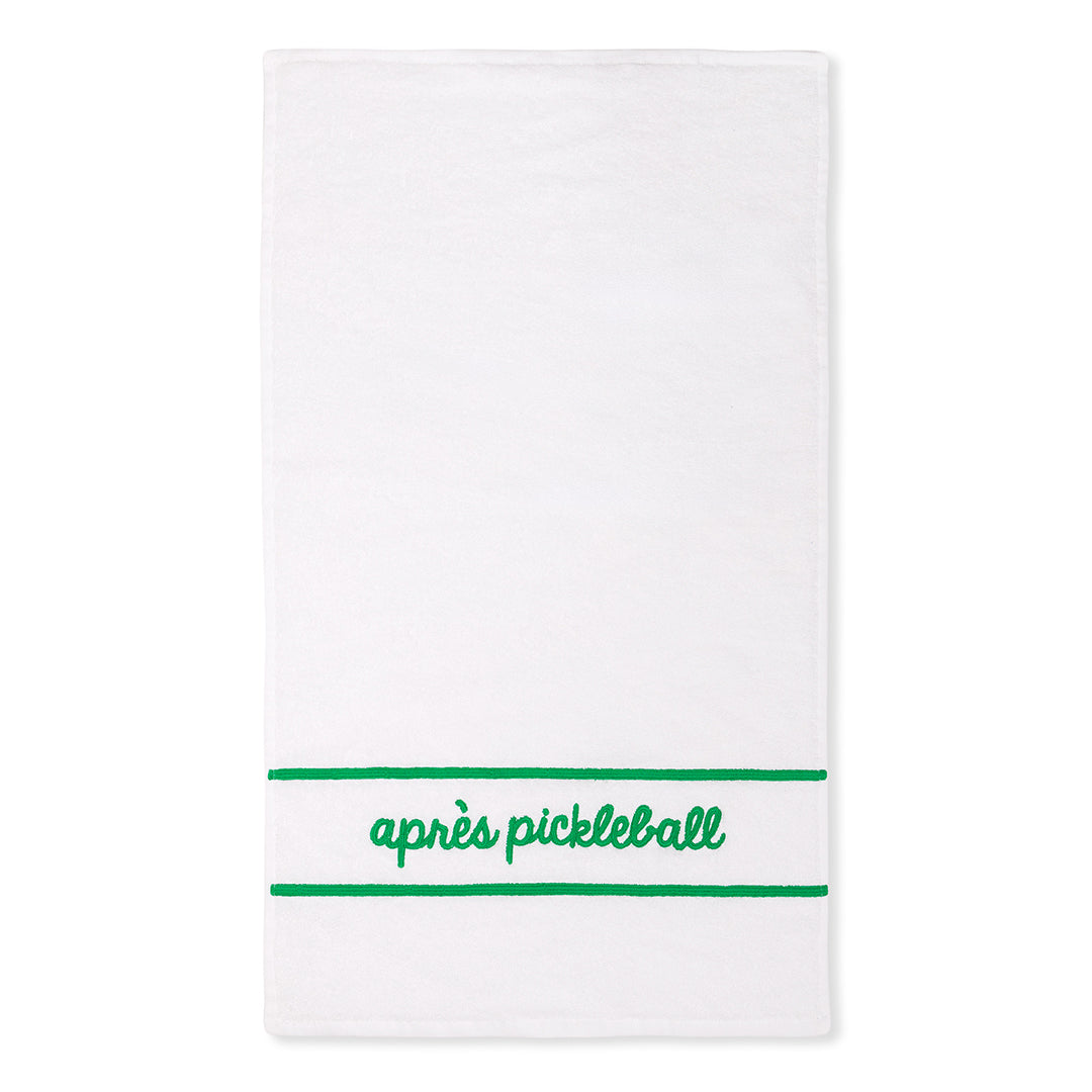 White cotton terry towel with "apres pickleball" embroidered in a green cursive font on the bottom of the towel