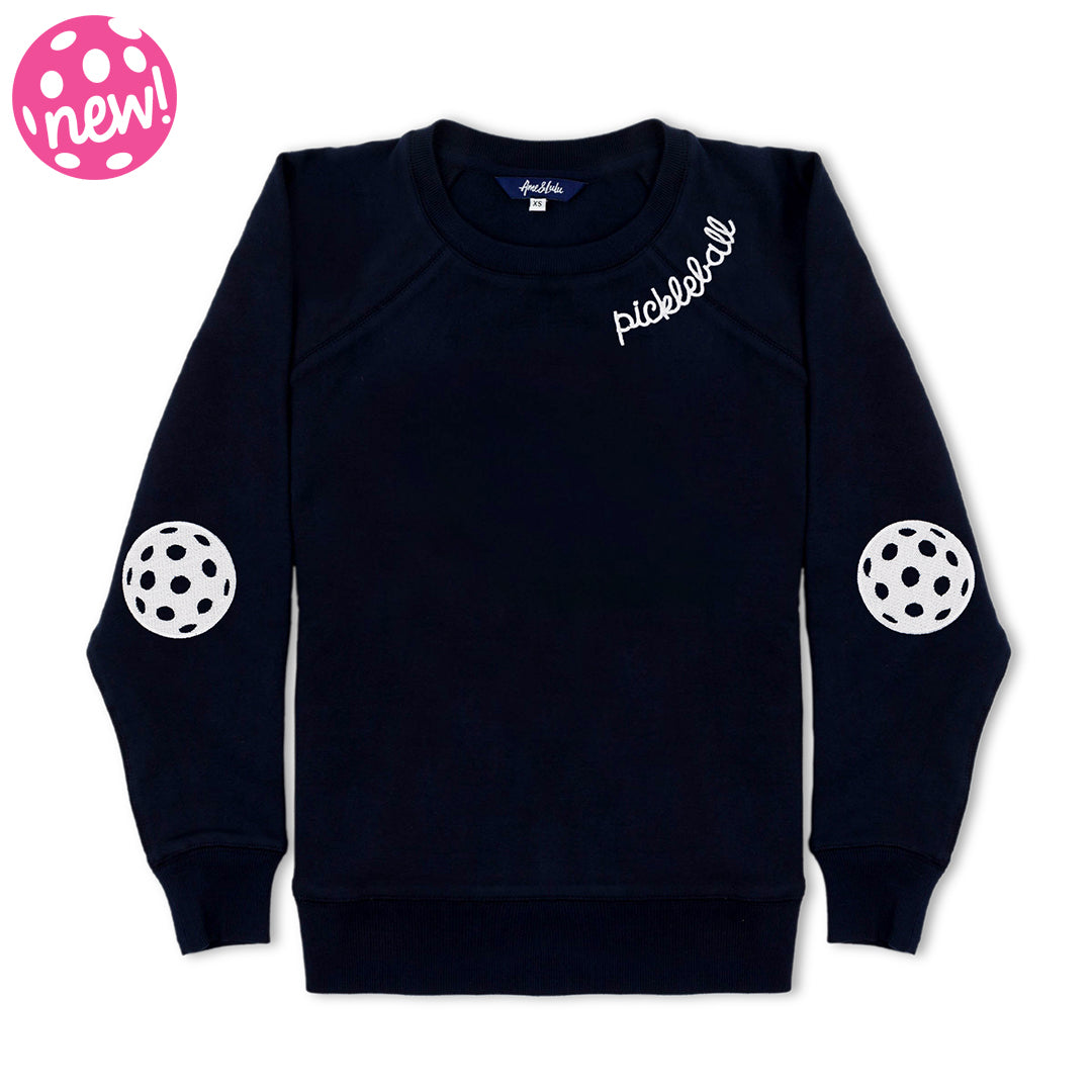 Womens navy sweatshirt with white embroidery on the neckline that reads "Pickleball" and white pickleball patches embroidered on the elbows