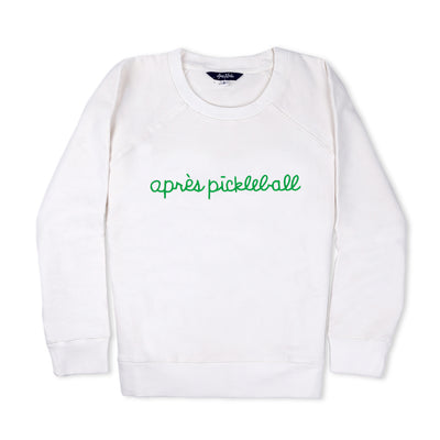 White sweatshirt lays flat on white background with green text reading apres pickleball embroidered on the front