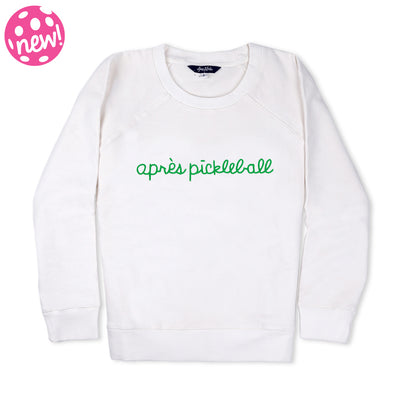 White sweatshirt lays flat on white background with green text reading apres pickleball embroidered on the front