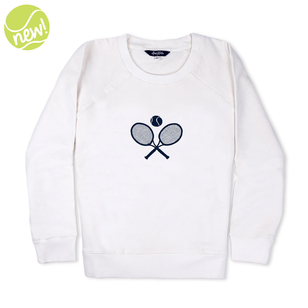 White sweatshirt lays flat on white background with navy crossed racquets embroidered on the front