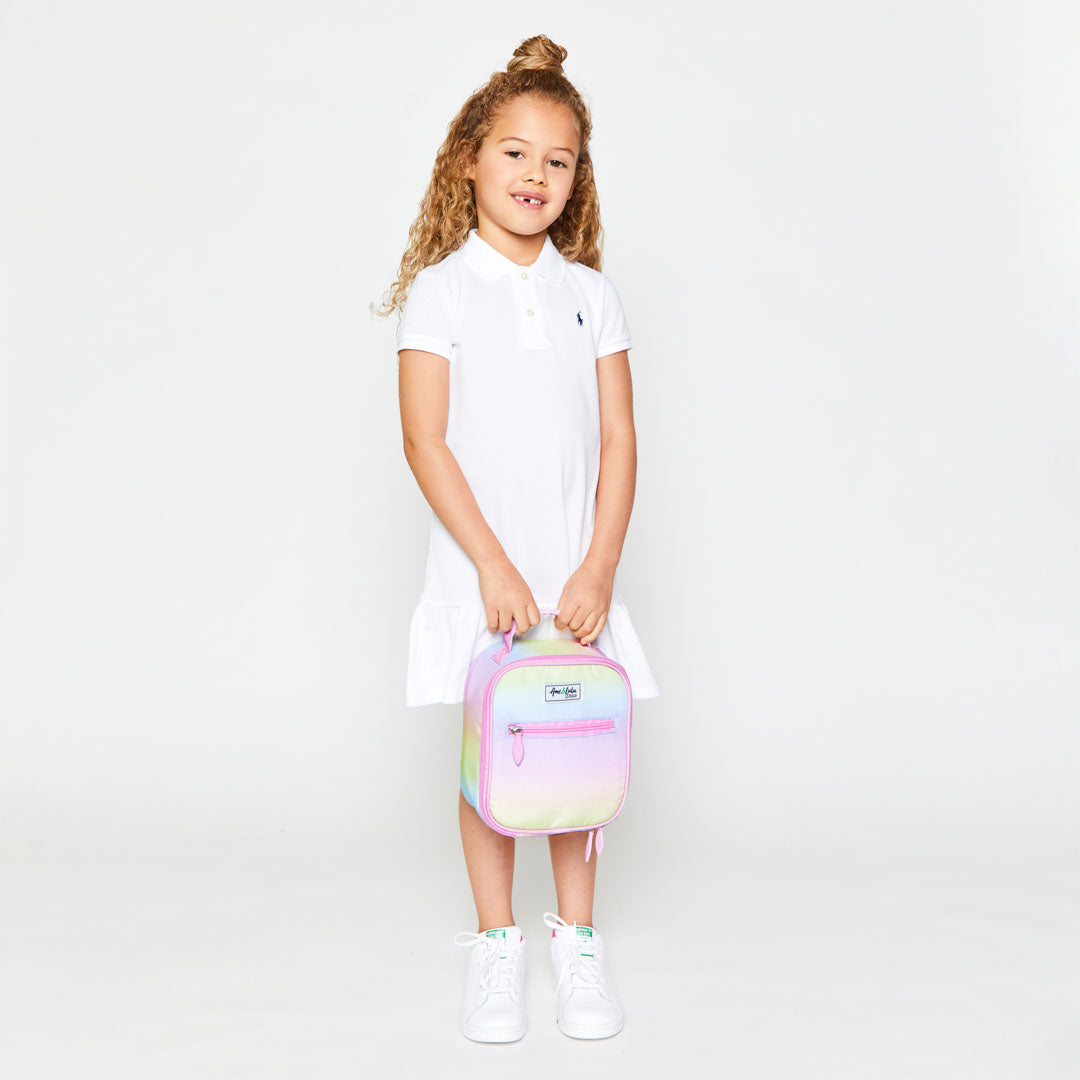 Little girl holds pastel rainbow ombre kids lunch box