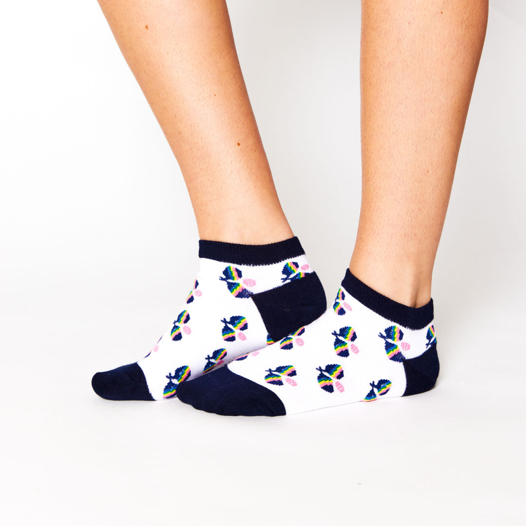 woman wearing white ankle socks with rainbow crossed paddle pattern repeated