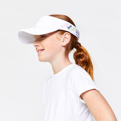 Little girl wearing white kids visor with the words hello love in the colors pink green and navy printed on the sides.