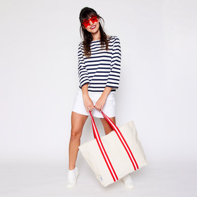woman with natural canvas tote with red and white cotton webbing straps