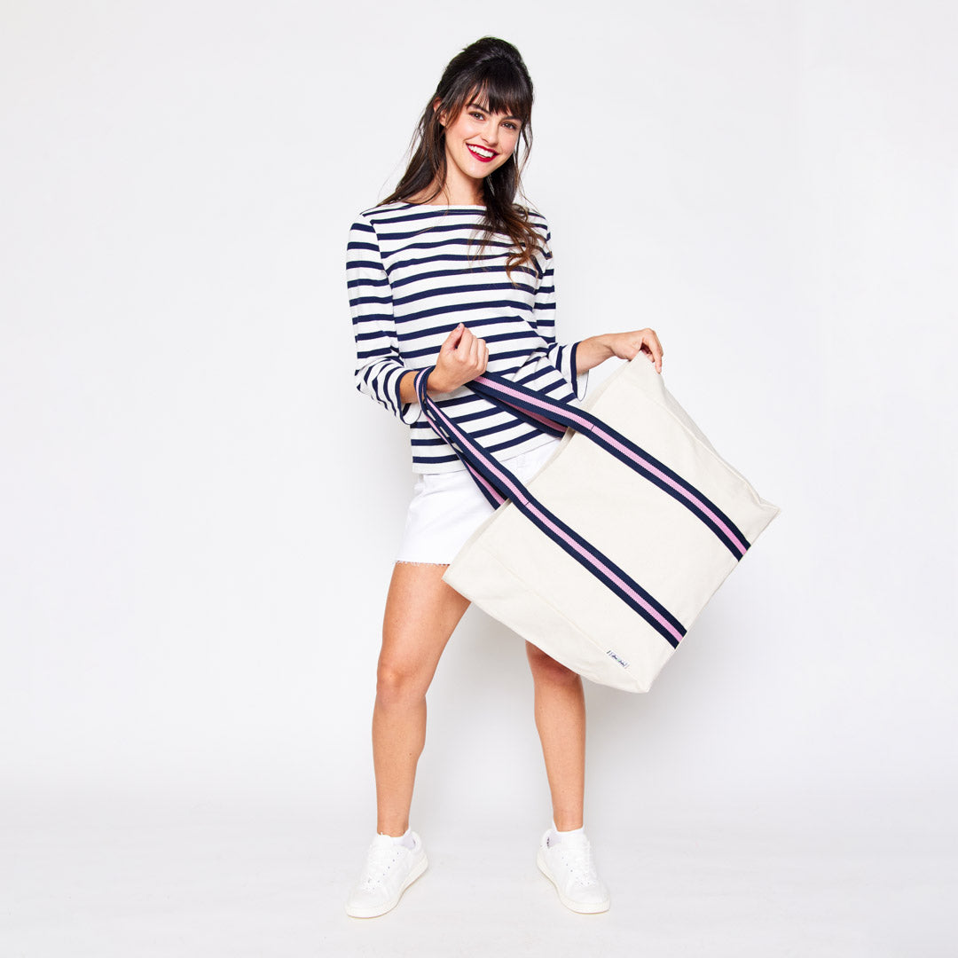 woman holding natural canvas tote with pink and navy cotton webbing straps