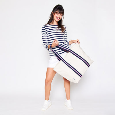 woman holding natural canvas tote with pink and navy cotton webbing straps