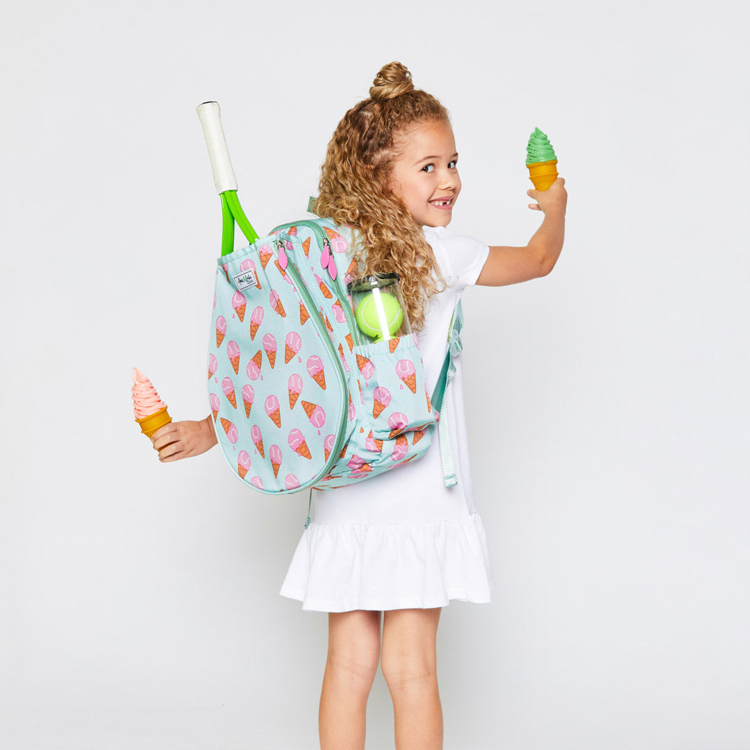 little girl stands wearing mint green kids tennis backpack with pink ice cream tennis balls pattern
