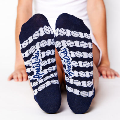 woman wears a pair of navy socks with white repeating tennis balls pattern