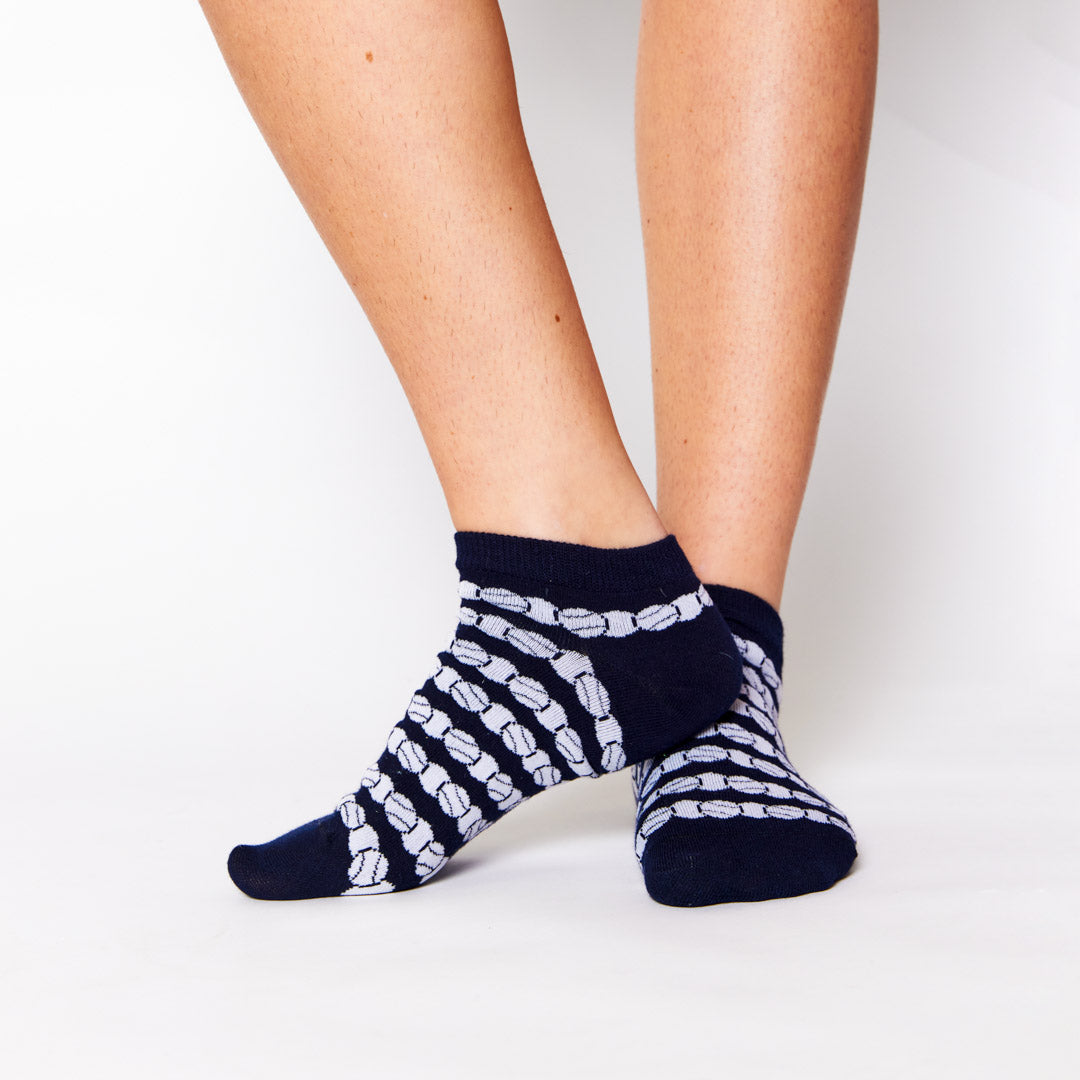 woman wears a pair of navy socks with white repeating tennis balls pattern
