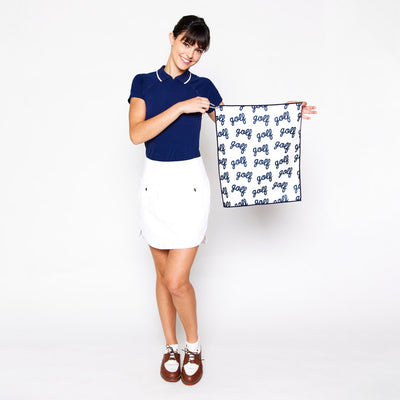 woman holds small white towel with word golf with cursive pattern