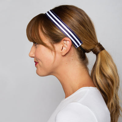a woman wears a white and navy striped headband with black elastic
