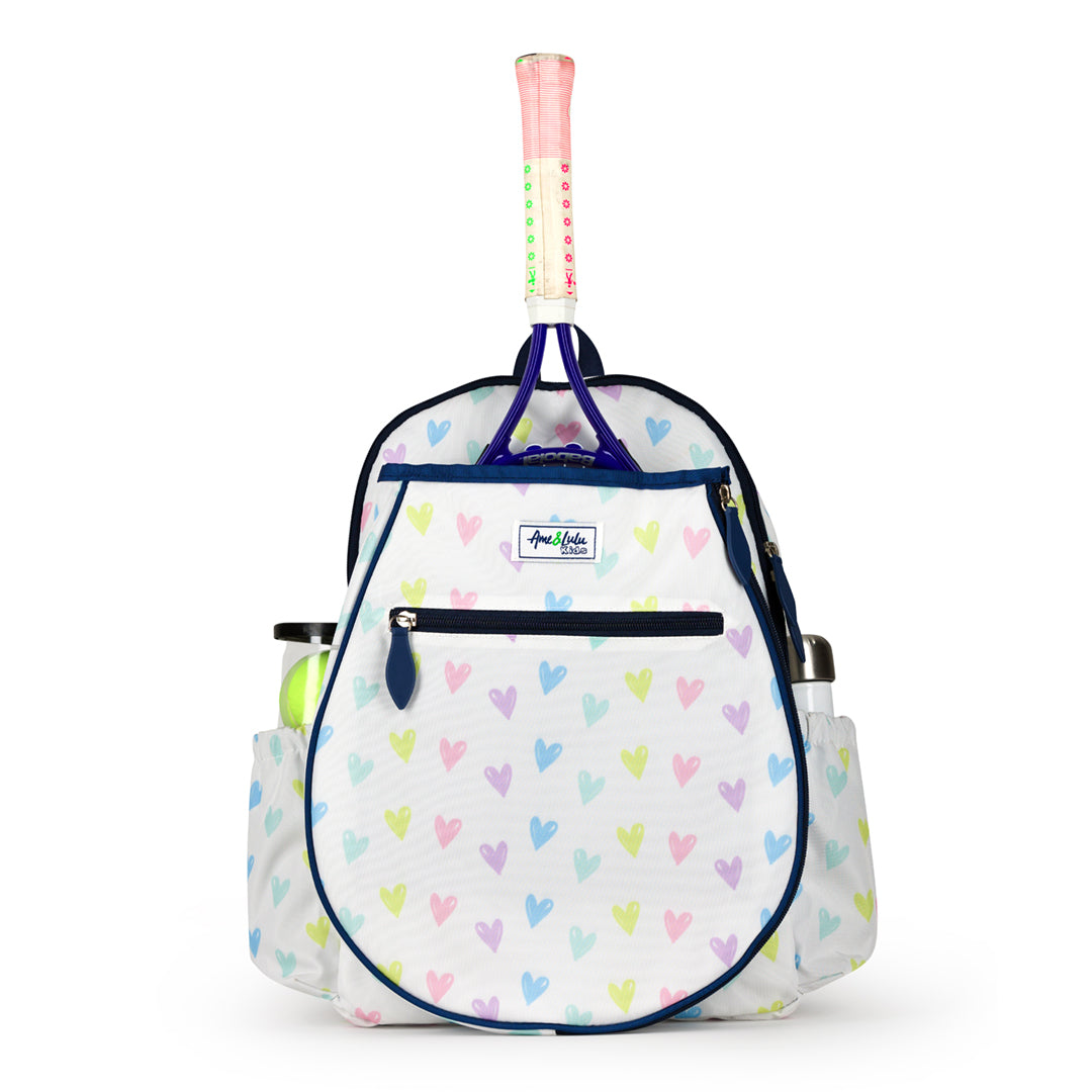 Front view of white kids tennis backpack with repeating pattern of rainbow hand drawn hearts.