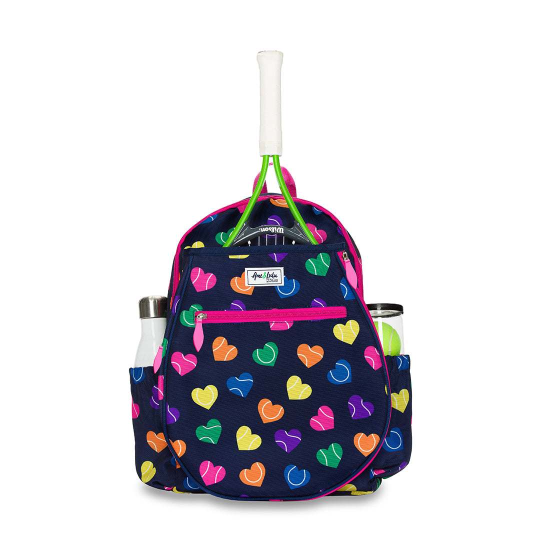 Front view of navy kids tennis backpack with repeating rainbow heart shaped tennis balls pattern.