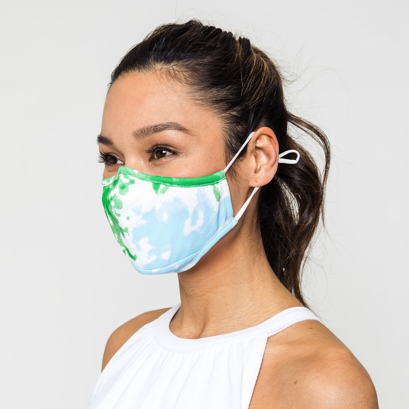 woman wears green and light blue tie dye pattern face mask
